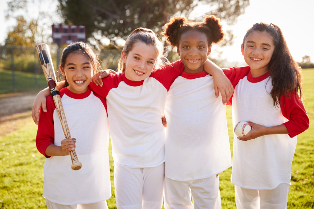 A group of female kids going to play baseball