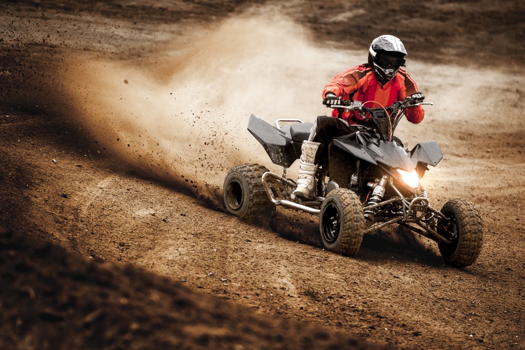 An ATV racer in action, wearing full-gear